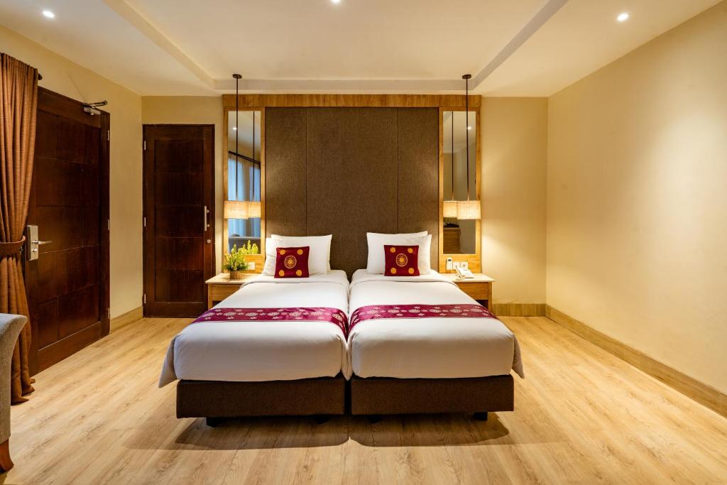 a bedroom with a large bed with red pillows at Bali Sunshine Nusa Dua in Nusa Dua