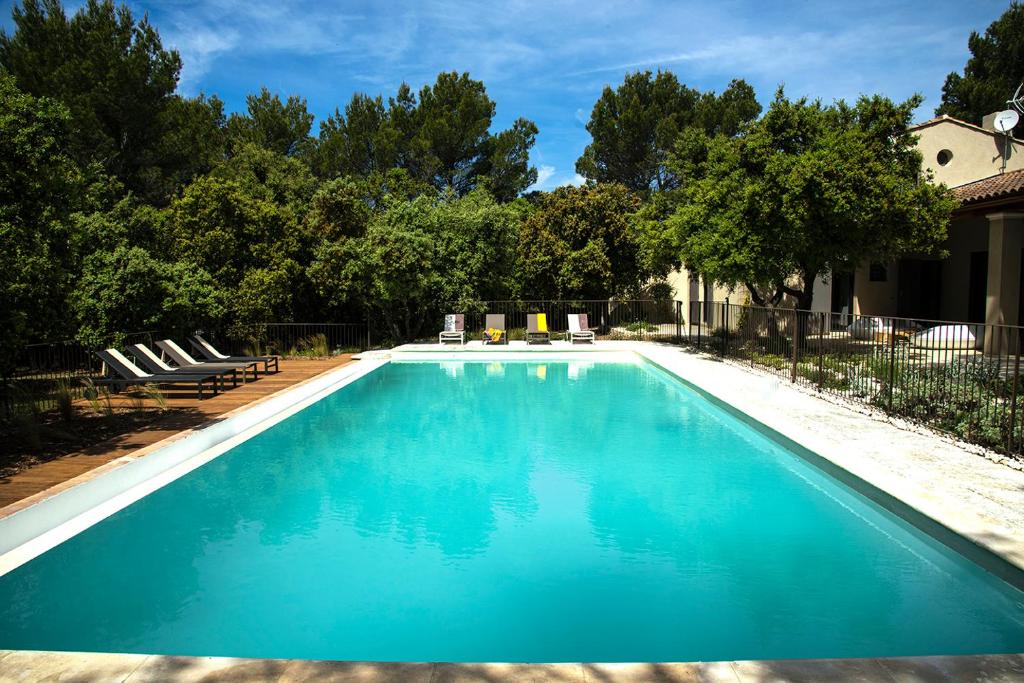 Una piscina con agua azul en un patio. en La maison de Brigitte, en LʼIsle-sur-la-Sorgue