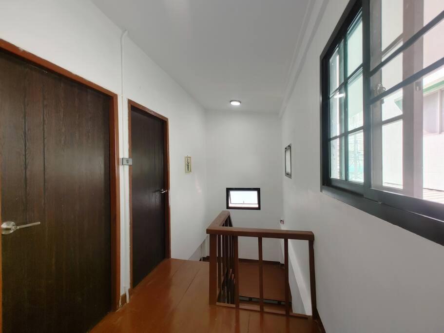 a hallway with a wooden door and a window at 辉煌夜市 4房泳池花园别墅 订4日提供免费接机 in Ban Na Song