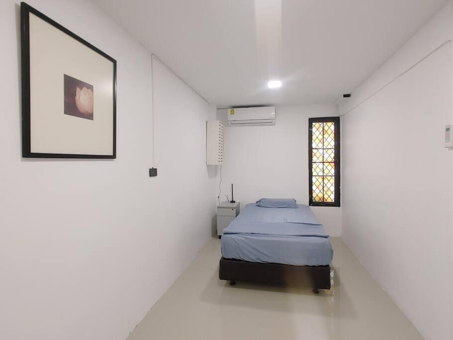 a bedroom with a bed in a white room at 辉煌夜市 4房泳池花园别墅 订4日提供免费接机 in Ban Na Song