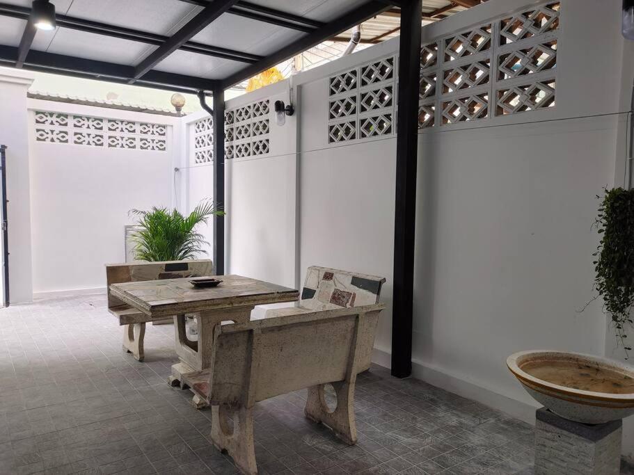 a room with a table and a bench in a room at 辉煌夜市 4房泳池花园别墅 订4日提供免费接机 in Ban Na Song