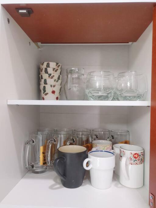 a shelf with cups and other glass items on it at 辉煌夜市 4房泳池花园别墅 订4日提供免费接机 in Ban Na Song
