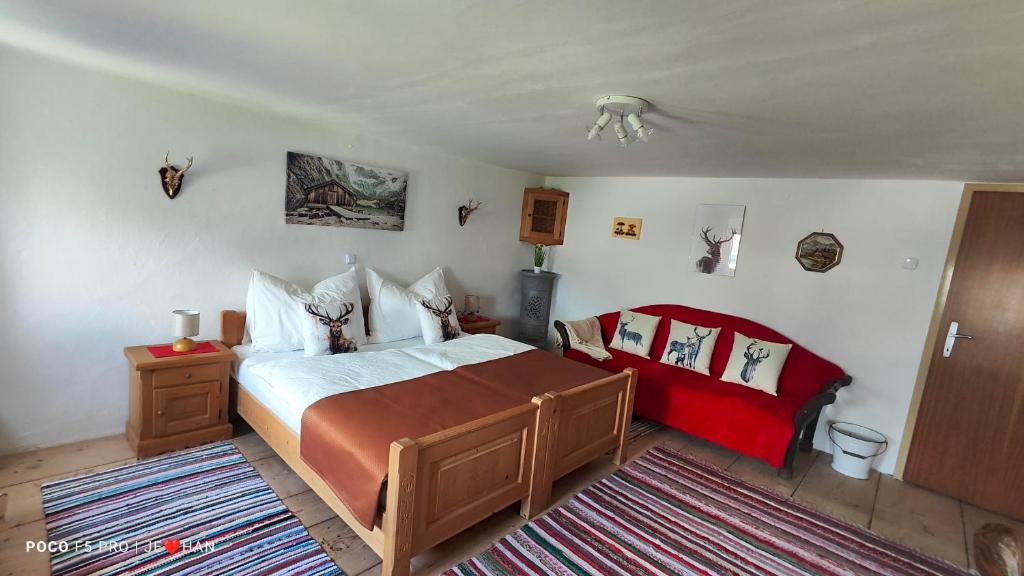 una camera da letto con un letto grande con un copriletto rosso di Ferienhaus Strassgartl a Pinsdorf
