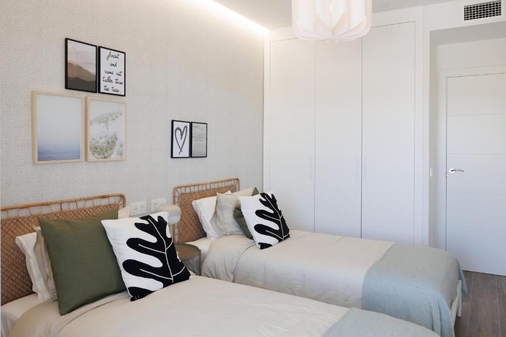 a bedroom with two beds and a couch at Ranhomes rentals apartments in Nueva Andalucia
