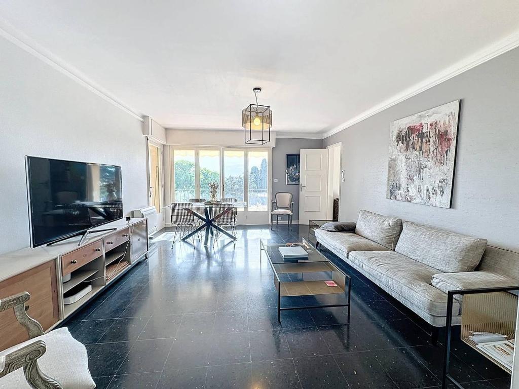 un salon avec un canapé et une télévision à écran plat dans l'établissement MIA2 - 3 pièces avec terrasse, à Cannes