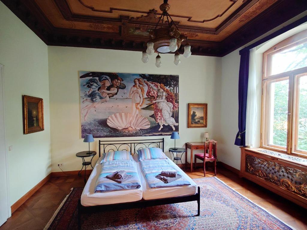 a bedroom with two beds and a painting on the wall at Ferienwohnung Villa Haniel Edmund in Dresden