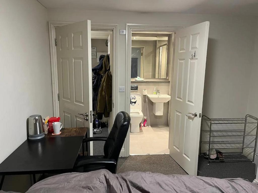 a bedroom with a door open to a bathroom with a sink at Room with Bathroom next to Sheffield Cathedral City Centre in Sheffield
