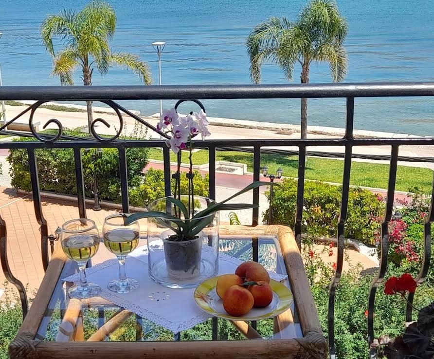 a table with a plate of fruit and glasses of wine at Marina Studios I in Argostoli