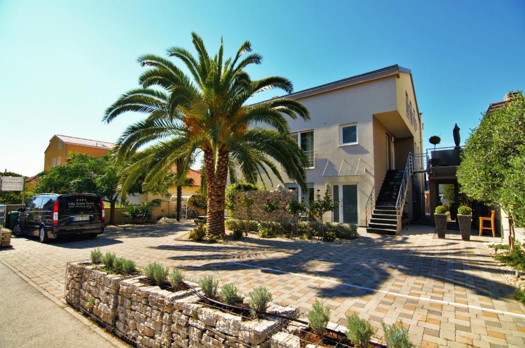 a palm tree in front of a house at Villa Diana Zadar in Zadar