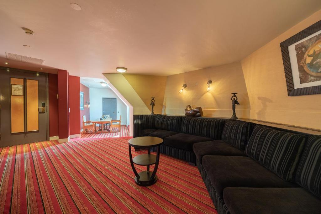 a living room with a couch and a red carpet at Grand Hotel Amrâth Amsterdam in Amsterdam