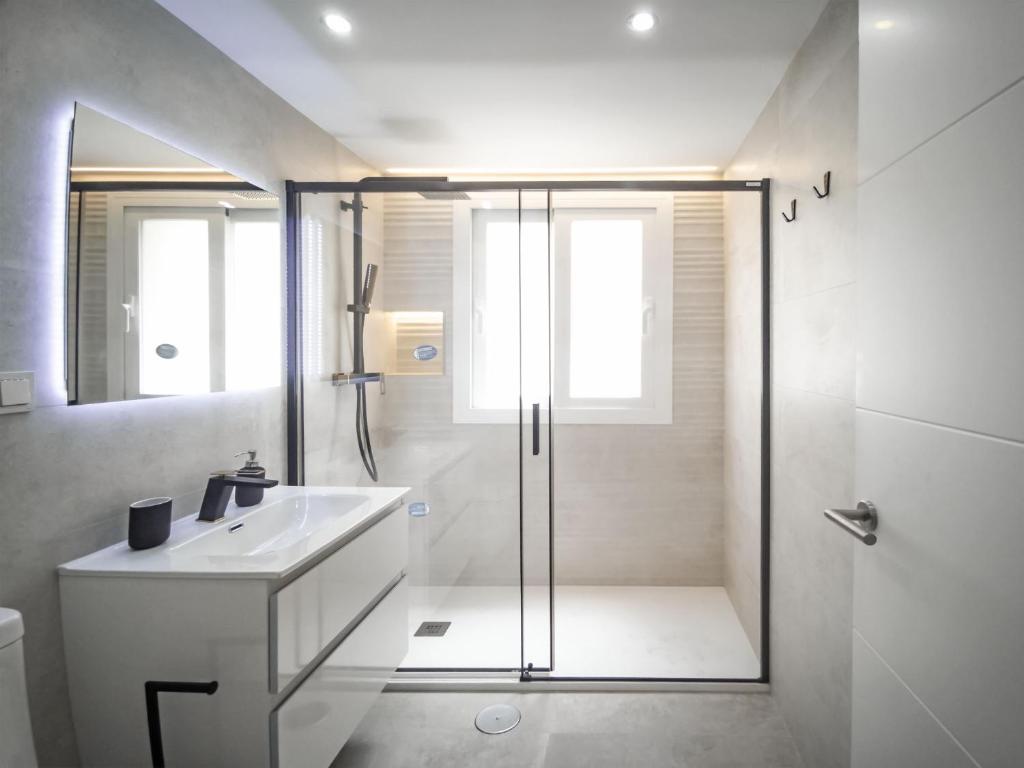 a white bathroom with a shower and a sink at Banana Beach in Marbella