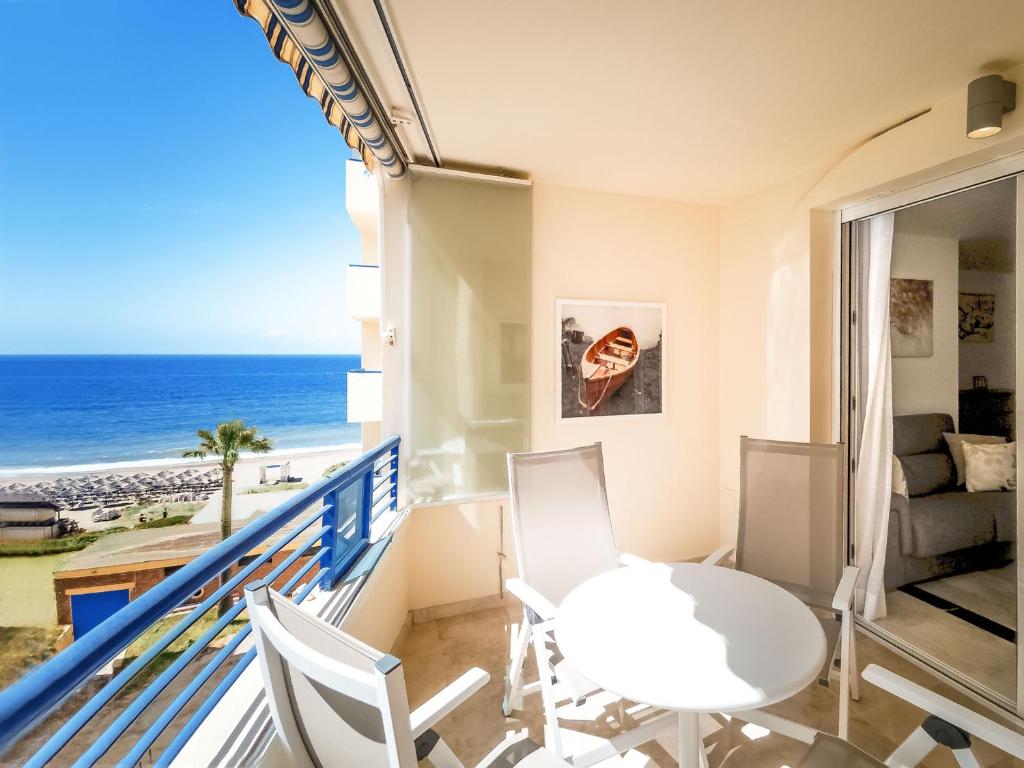 a balcony with a table and chairs and the ocean at Banana Beach in Marbella