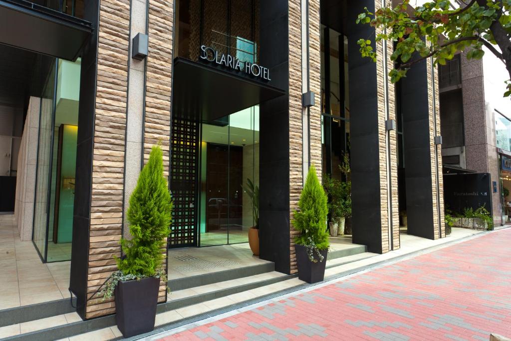 a building with potted plants in front of it at Solaria Nishitetsu Hotel Ginza in Tokyo