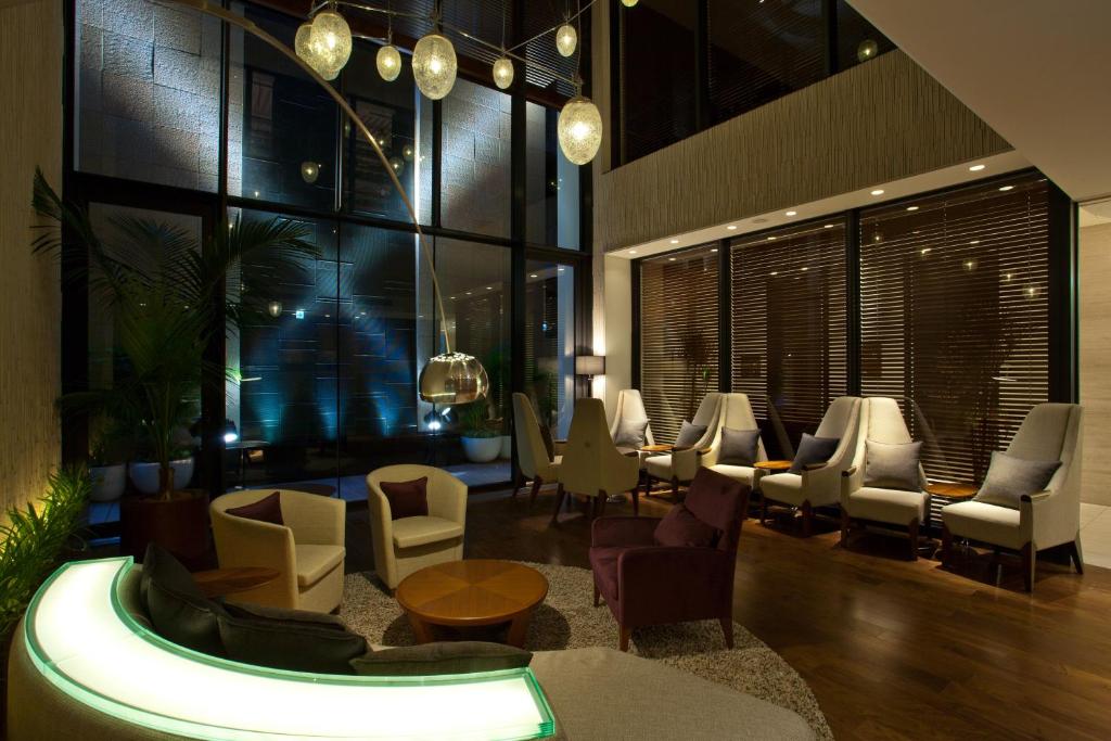 a lobby with a waiting area with chairs and tables at Solaria Nishitetsu Hotel Ginza in Tokyo