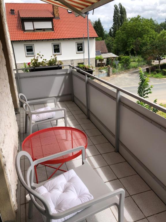 a balcony with two chairs and a table at Rote Etage Pension mit Balkon, 4 km von Kitzingen nur 16 km von Würzburg! in Mainstockheim