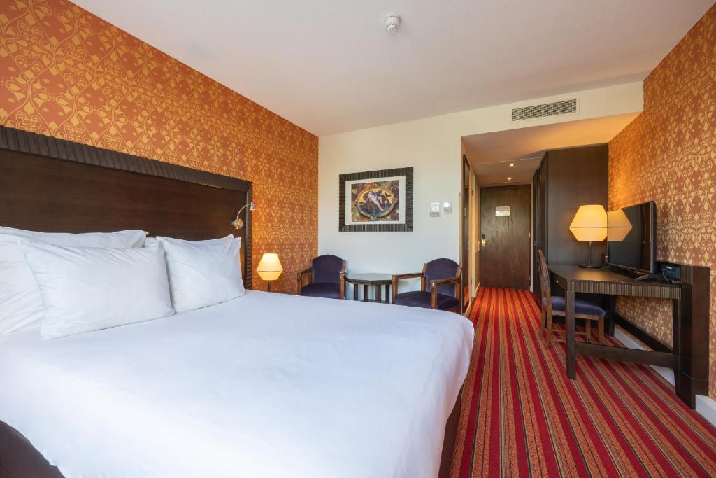 a hotel room with a large bed and a desk at Grand Hotel Amrâth Amsterdam in Amsterdam