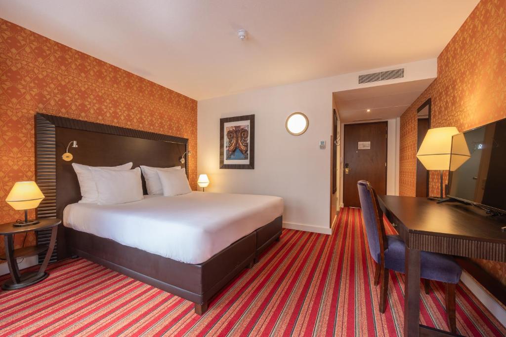 a hotel room with a bed and a desk at Grand Hotel Amrâth Amsterdam in Amsterdam