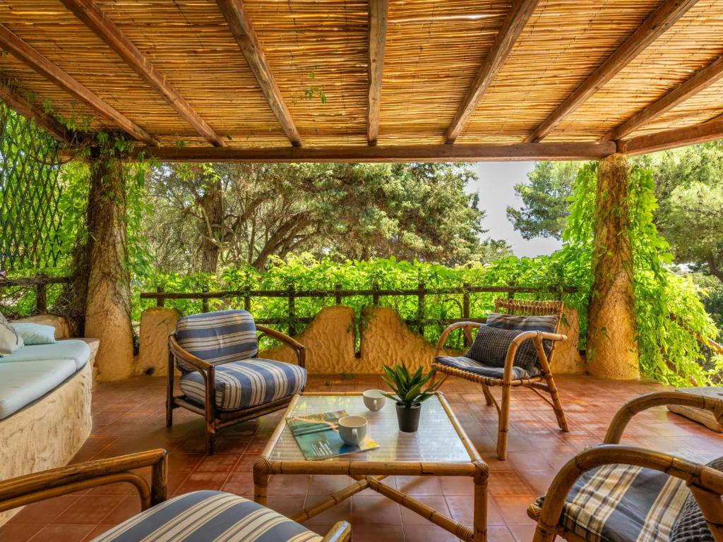 a porch with chairs and a couch and a table at Villa La Casetta del Mare by Interhome in Villasimius