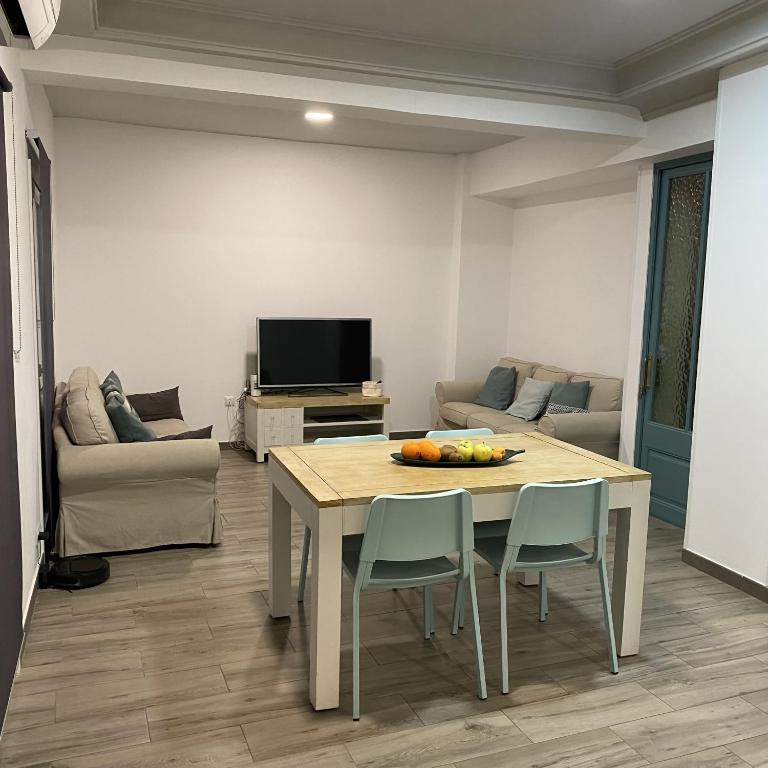 ein Wohnzimmer mit einem Tisch, Stühlen und einem TV in der Unterkunft Cal Feliu Piso amplio en el centro de Reus in Reus