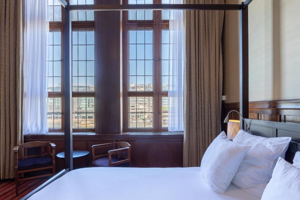 a hotel room with a bed and windows at Grand Hotel Amrâth Amsterdam in Amsterdam