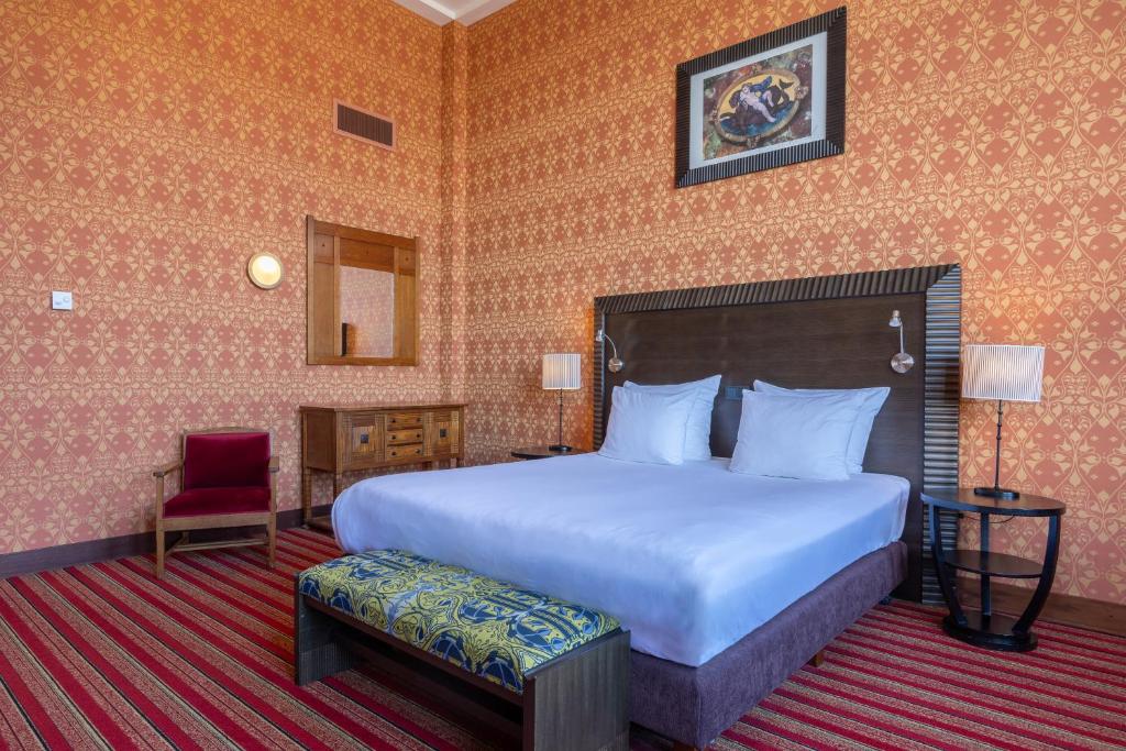a hotel room with a bed and a chair at Grand Hotel Amrâth Amsterdam in Amsterdam