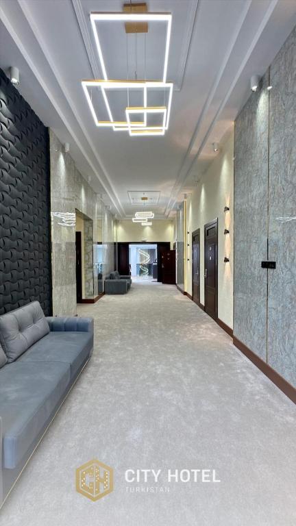 a large room with a couch in the middle of a building at City Hotel Turkistan in Türkistan