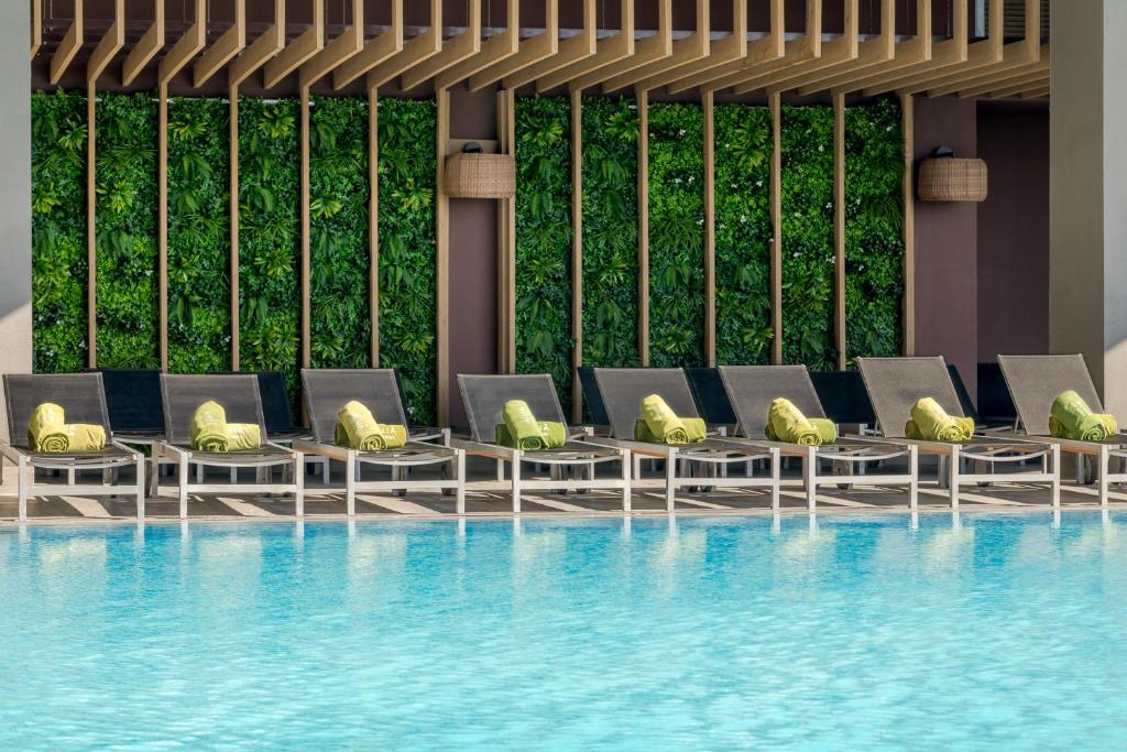 a row of lounge chairs next to a swimming pool at Melia Alicante in Alicante