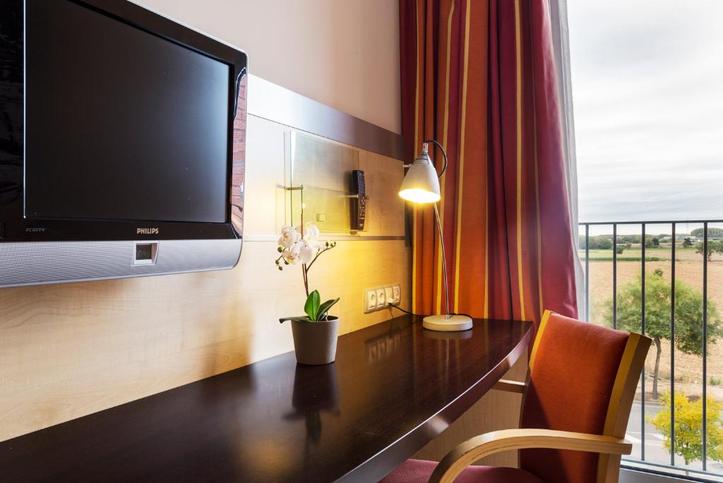 撒爾特的住宿－B&B HOTEL Girona 3，客房设有书桌、电视和窗户。