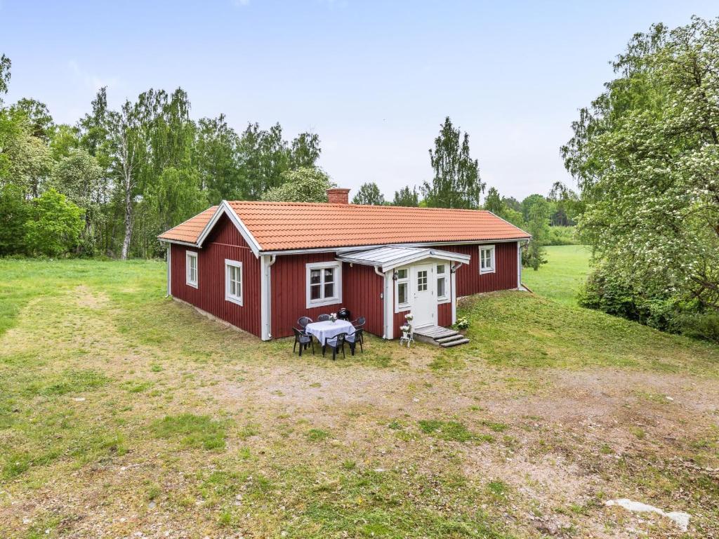 a red house with a table in front of it at Chalet Motorp by Interhome in Arboga