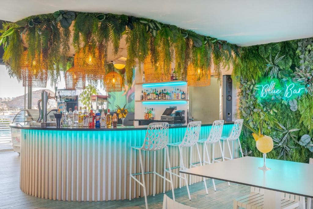 a bar with tables and chairs in a restaurant at Melia Alicante in Alicante