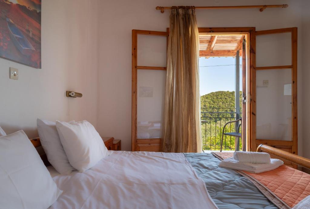 a bedroom with a bed and a window with a view at Ulisse Apartments in Paleokastritsa