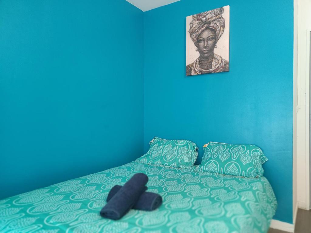 a blue bedroom with a bed with a blue wall at Paris cosy private room with shared space - Chambre privée avec espace commun Paris in Vitry-sur-Seine