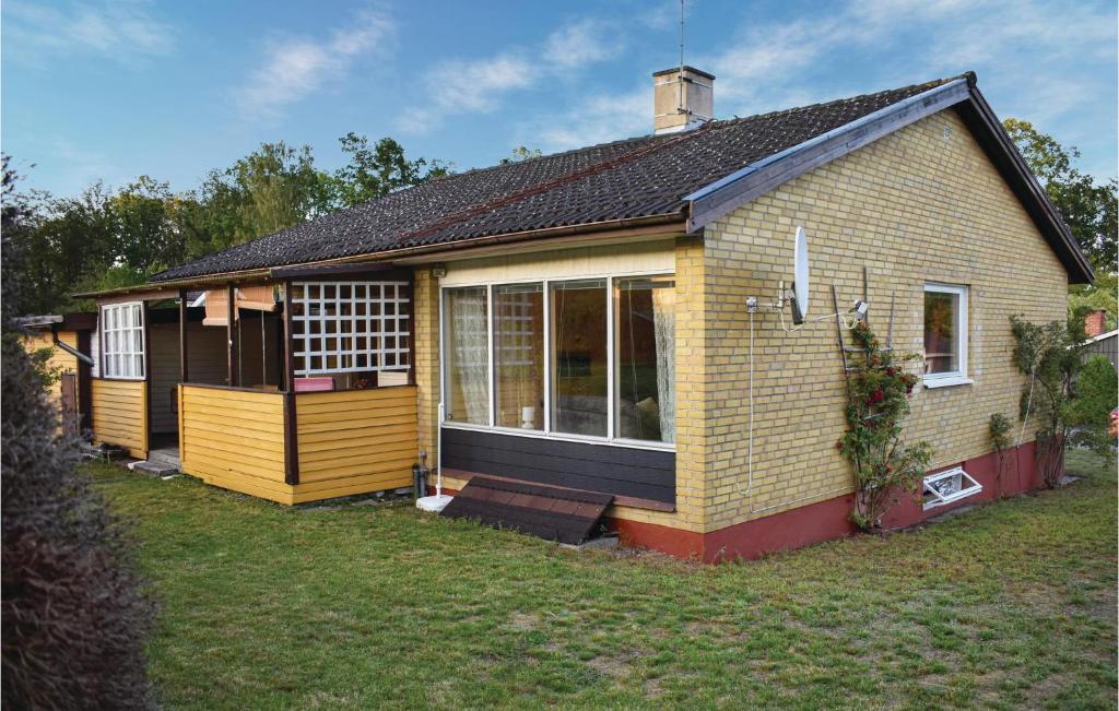 a small yellow house with a large window at Gorgeous Home In Hästveda With Kitchen in Hästveda