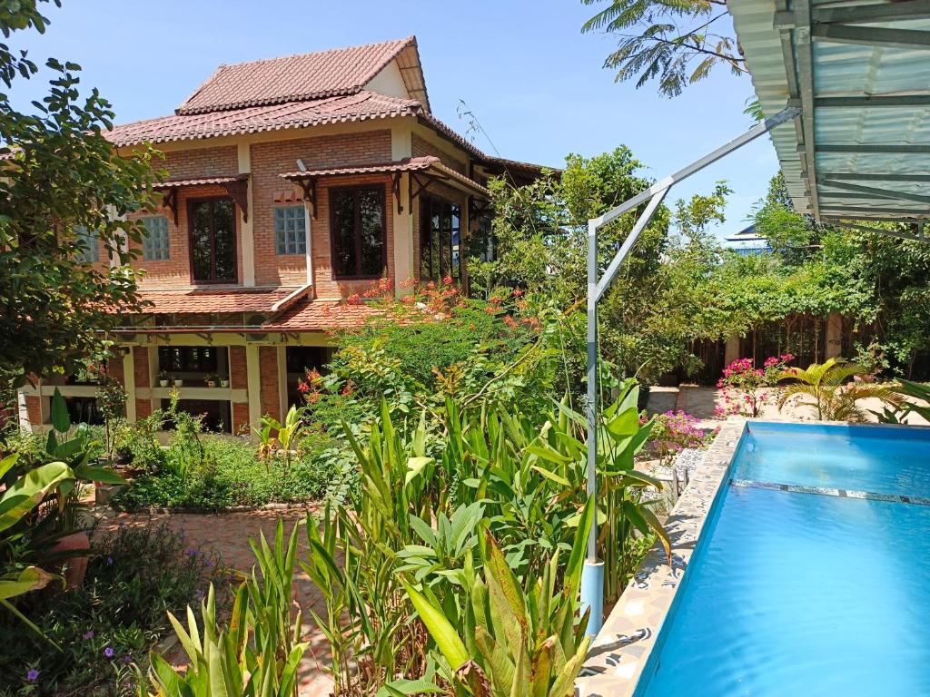 dom z basenem przed nim w obiekcie Silk Island Homestay 