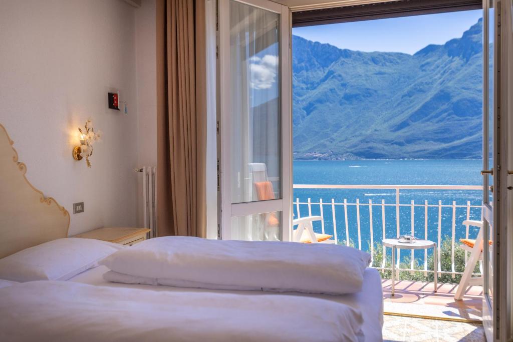 a bedroom with a balcony with a view of the ocean at Hotel Villa Margherita in Limone sul Garda