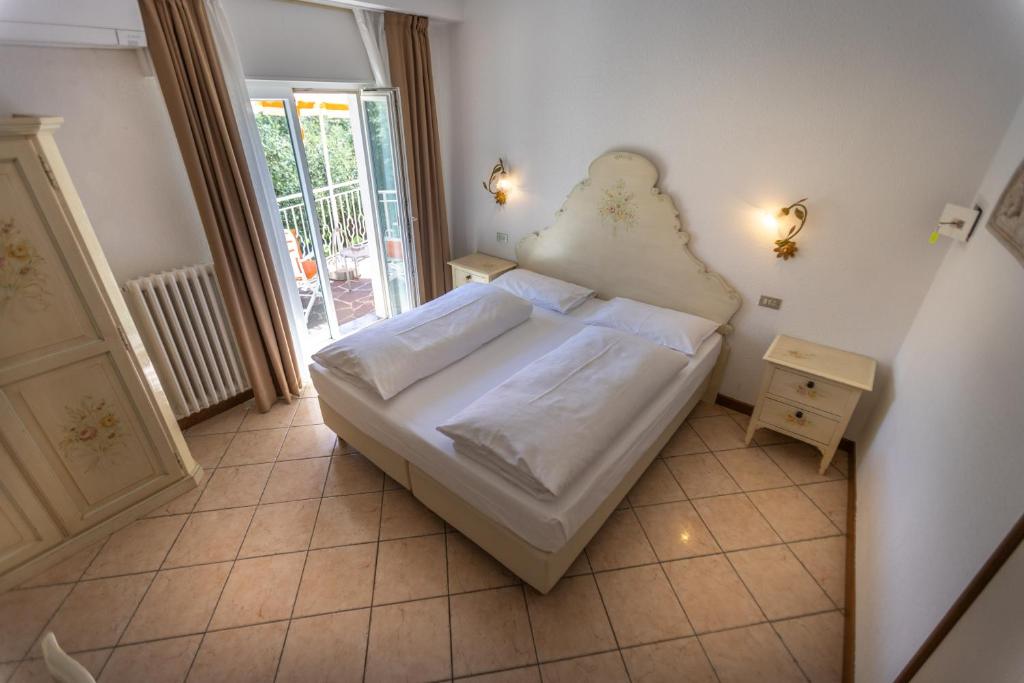 a small bedroom with a bed and a night stand at Hotel Villa Margherita in Limone sul Garda