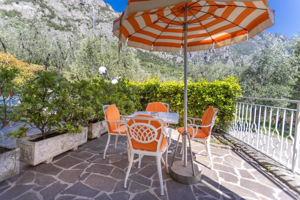 a table and chairs under an umbrella on a patio at Hotel Villa Margherita in Limone sul Garda