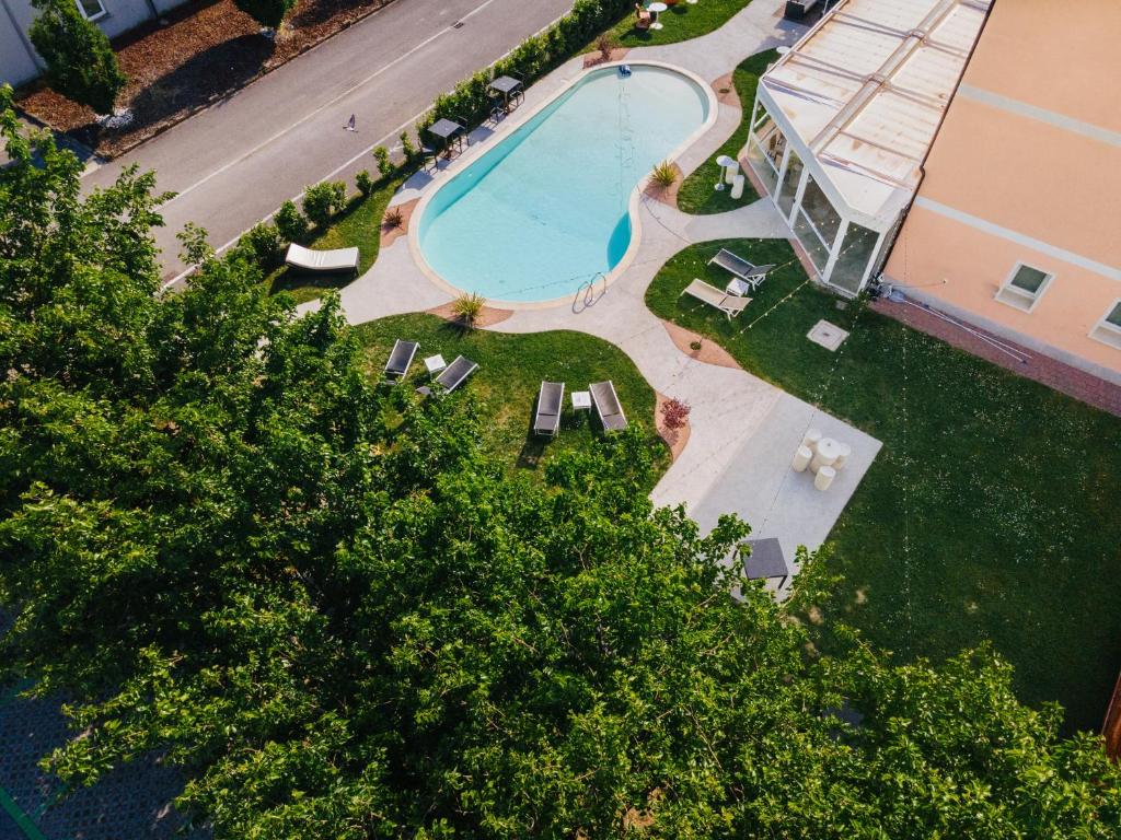widok na basen z krzesłami i drzewami w obiekcie B&B Podere Dell'Angelo w mieście Pasiano di Pordenone