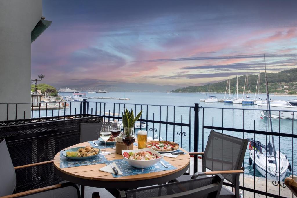 una mesa con comida y vino y vistas al agua en Ca' Amae Portovener e, en Portovenere