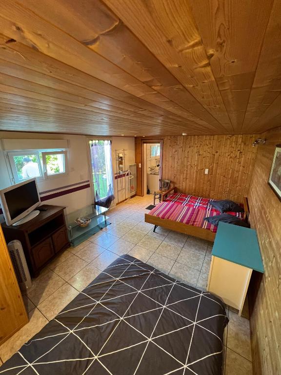 une chambre avec un lit et un bureau dans une pièce dans l'établissement Studio entre mer et montagnes, à Louhossoa