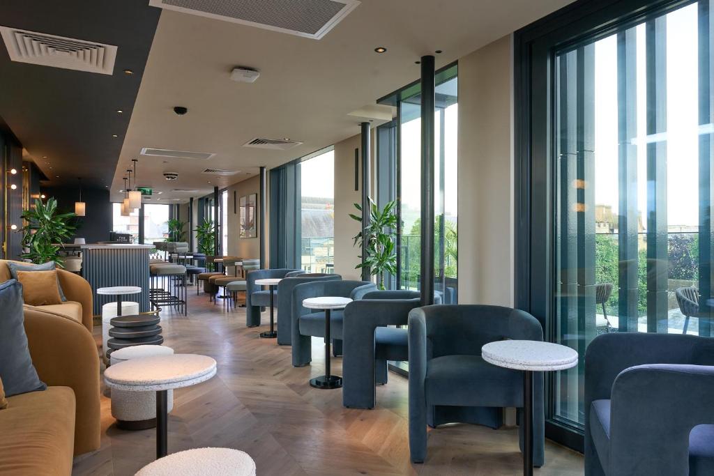 a waiting room with tables and chairs and windows at The Store in Oxford