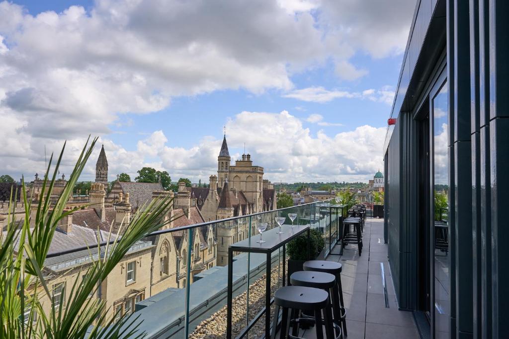 a balcony with stools and a view of a city at The Store in Oxford