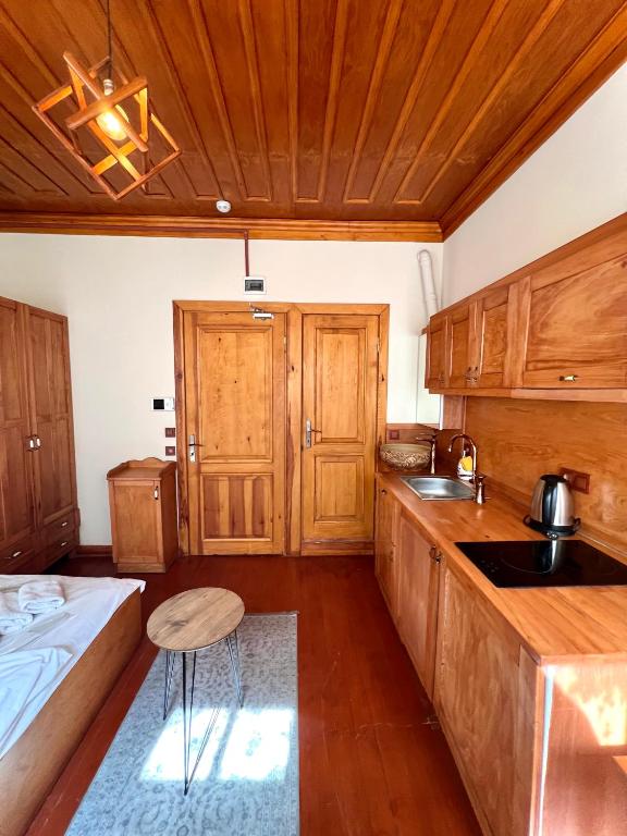 eine Küche mit Holzschränken, einem Waschbecken und einem Bett in der Unterkunft Authentic Turkish Home Studio Room in Istanbul