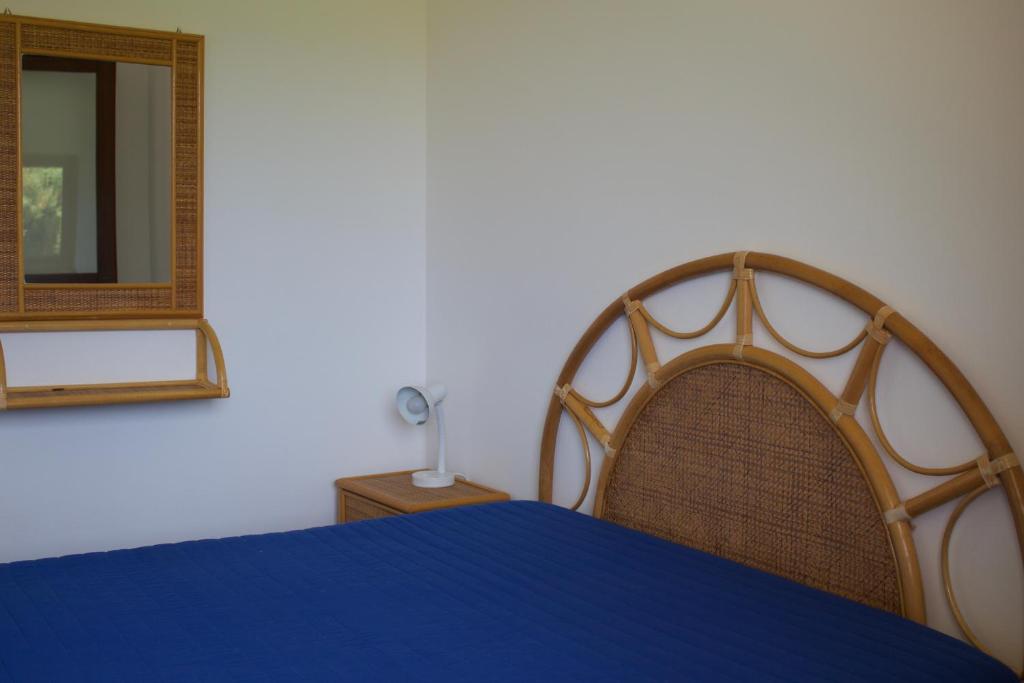 a bedroom with a blue bed and a mirror at Le Casette a Favignana in Favignana