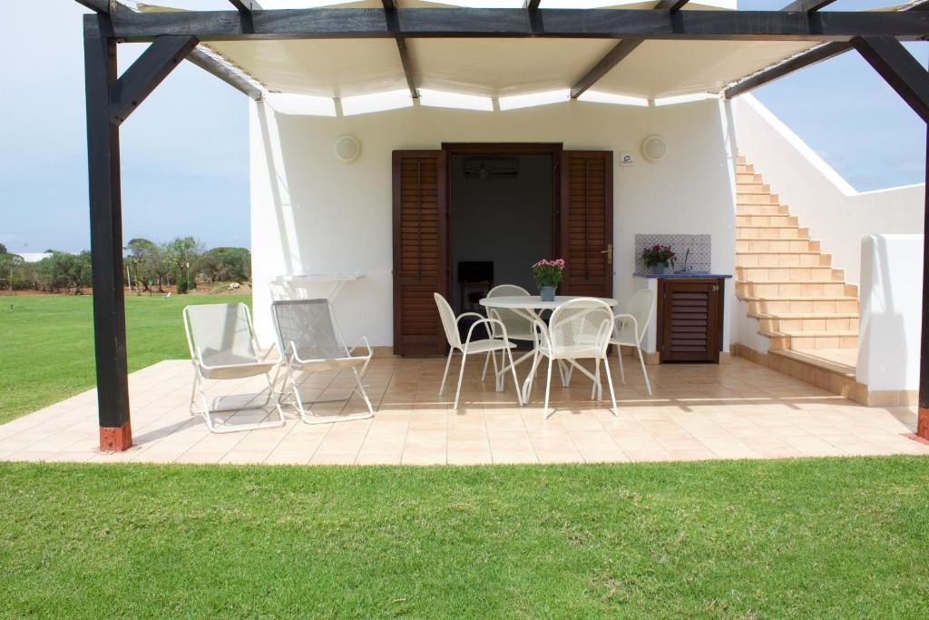 a patio with a table and chairs and stairs at Le Casette a Favignana in Favignana