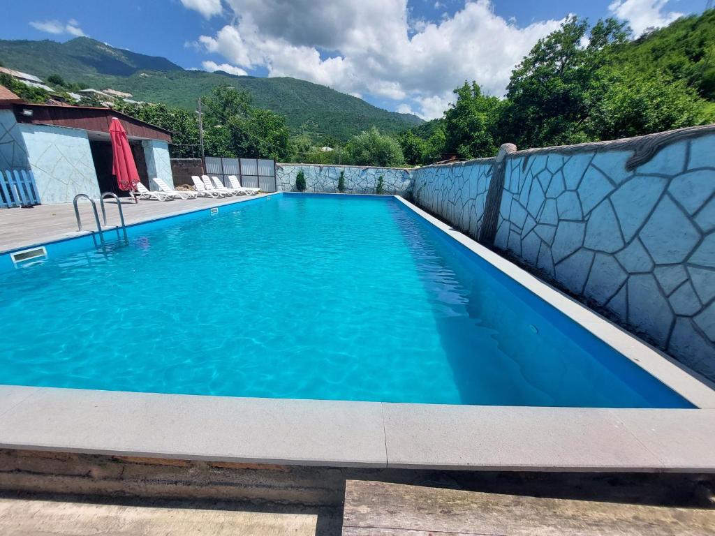 a swimming pool in a house with blue water at Spitak tun in Ijevan