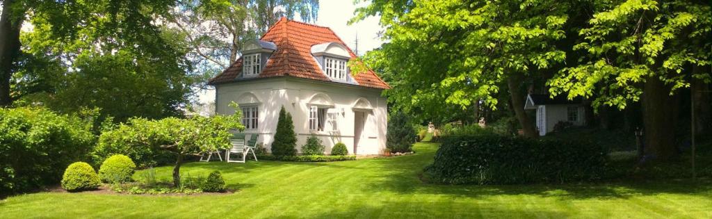 エッカーンフェルデにあるSimonの緑の芝生の上に赤い屋根の白い家