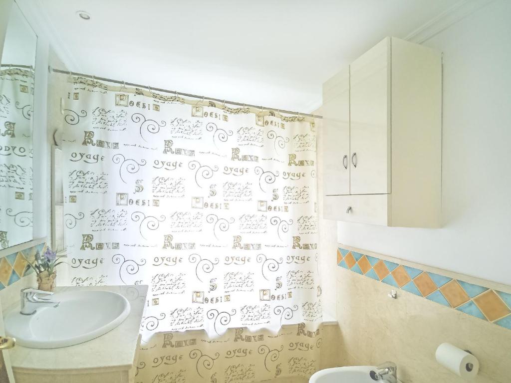 a bathroom with a shower curtain with writing on the wall at Banana Beach in Marbella