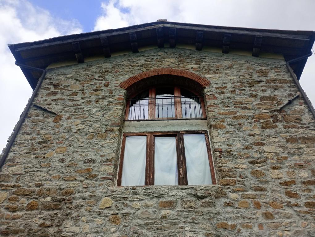 a window on the side of a brick building at Casa verdelago in Barberino di Mugello