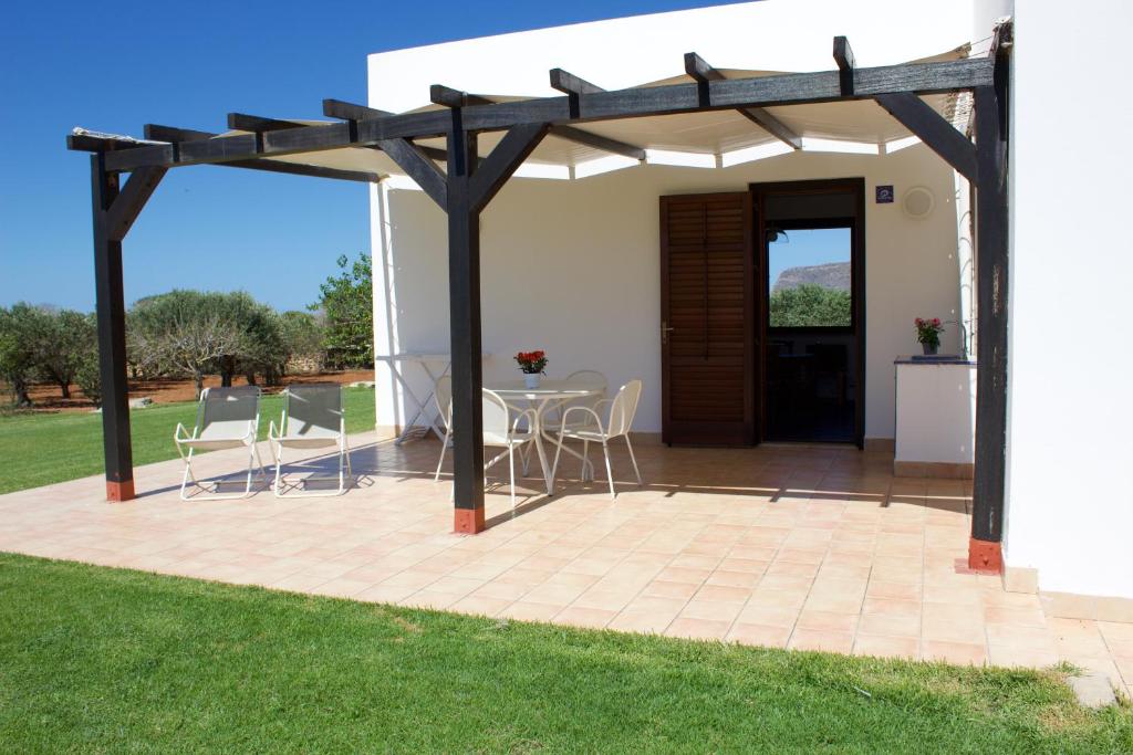 a pergola with a table and chairs on a patio at Le Casette a Favignana in Favignana
